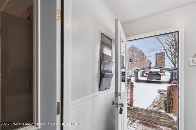 doorway to outside with tile walls