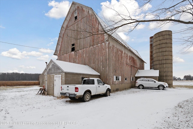 view of snow covered exterior featuring an outbuilding