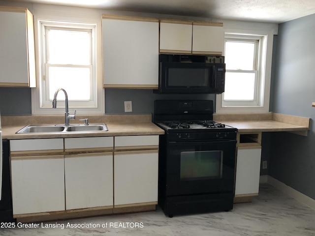 kitchen with white cabinetry, sink, black appliances, and a textured ceiling