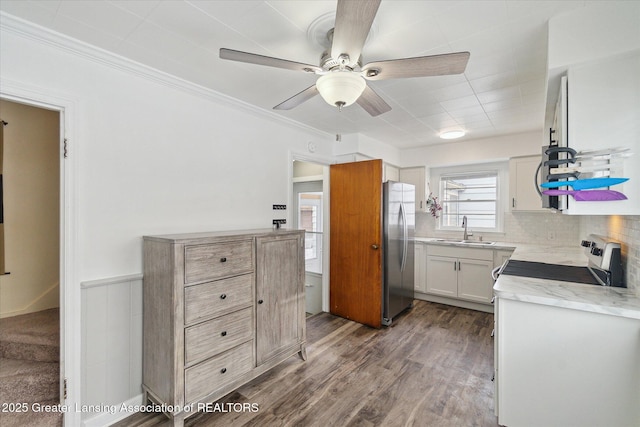 kitchen featuring appliances with stainless steel finishes, sink, hardwood / wood-style flooring, ceiling fan, and crown molding