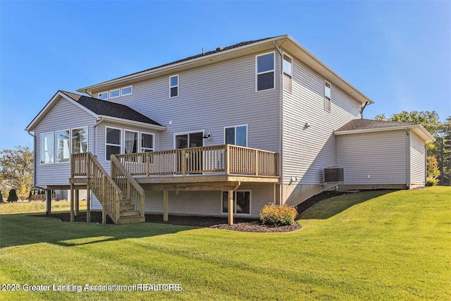 rear view of property featuring a wooden deck and a lawn