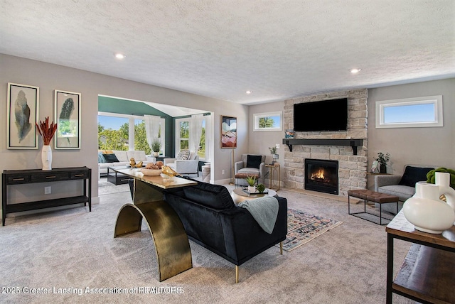 living room featuring light colored carpet, a textured ceiling, and a fireplace