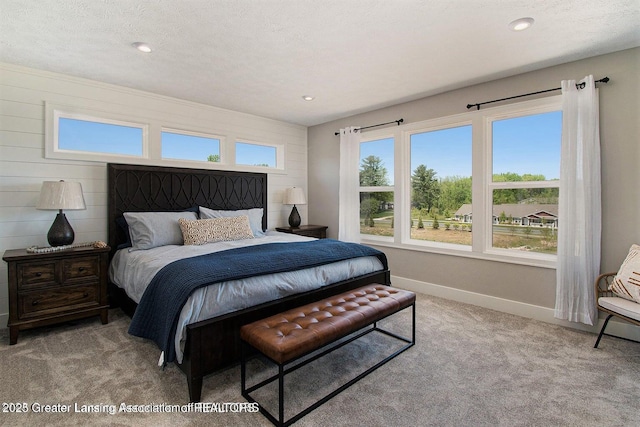 bedroom with multiple windows, light carpet, and a textured ceiling