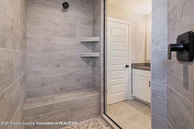 bathroom with vanity and a tile shower