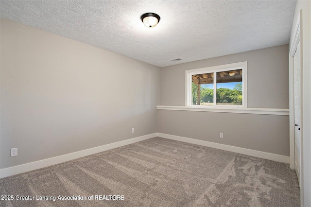 empty room with a textured ceiling and carpet