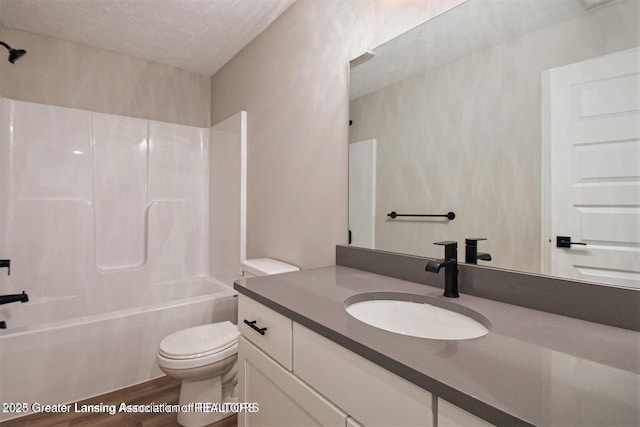 full bathroom featuring toilet, wood-type flooring, a textured ceiling, shower / washtub combination, and vanity