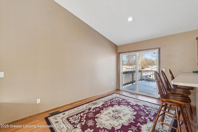 dining room with lofted ceiling and hardwood / wood-style floors