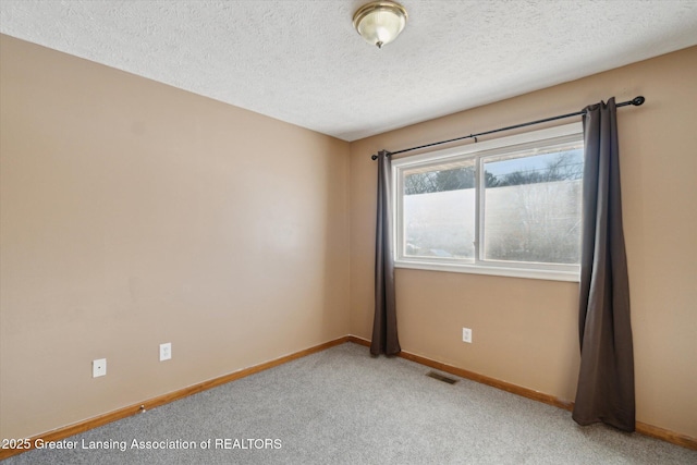 carpeted spare room with a textured ceiling