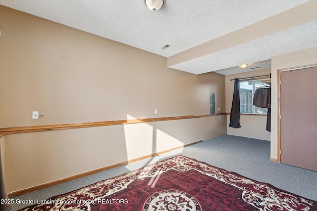 carpeted empty room featuring a textured ceiling