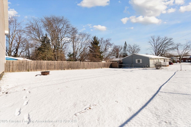 yard layered in snow with an outdoor fire pit