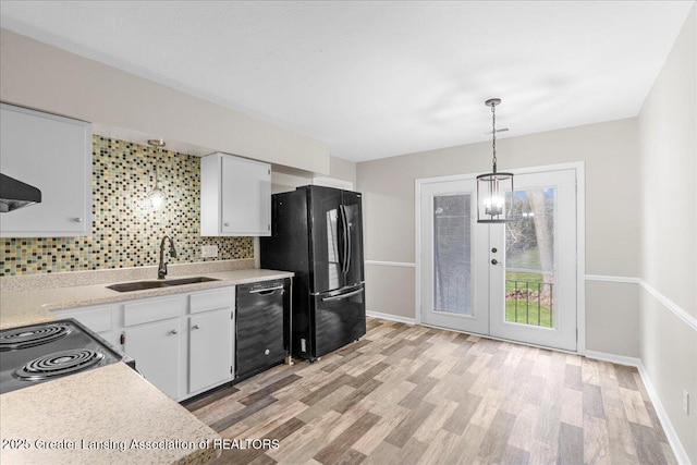 kitchen with pendant lighting, sink, white cabinetry, tasteful backsplash, and black appliances