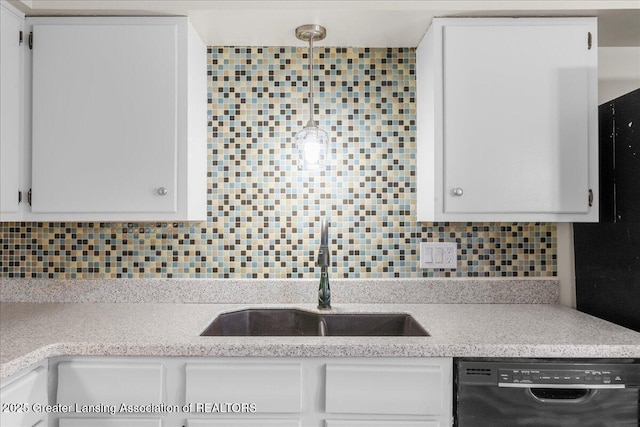 kitchen featuring black dishwasher, sink, white cabinets, backsplash, and hanging light fixtures