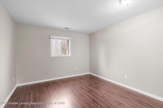 unfurnished room featuring dark wood-type flooring