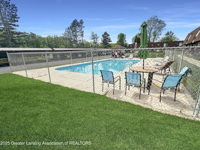 view of swimming pool featuring a patio area and a lawn