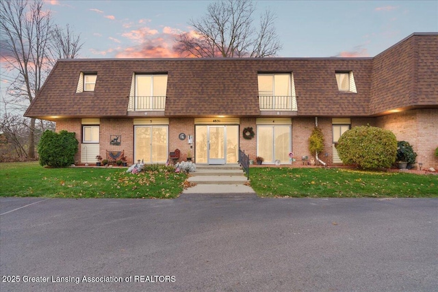 multi unit property with a yard and a balcony