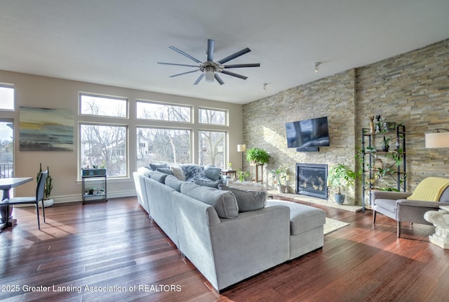 living room featuring dark hardwood / wood-style flooring, a fireplace, and ceiling fan