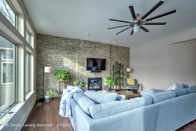 living room with dark hardwood / wood-style flooring, a fireplace, and ceiling fan