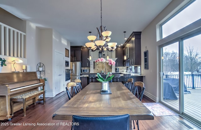 dining space with a notable chandelier and dark wood-type flooring