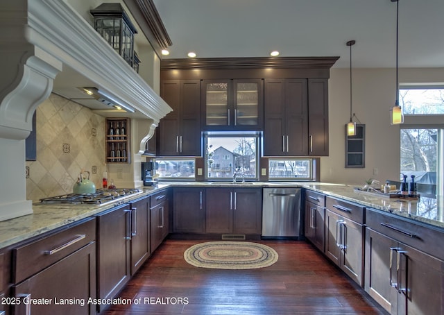 kitchen featuring light stone counters, dark brown cabinets, hanging light fixtures, dark hardwood / wood-style flooring, and stainless steel appliances