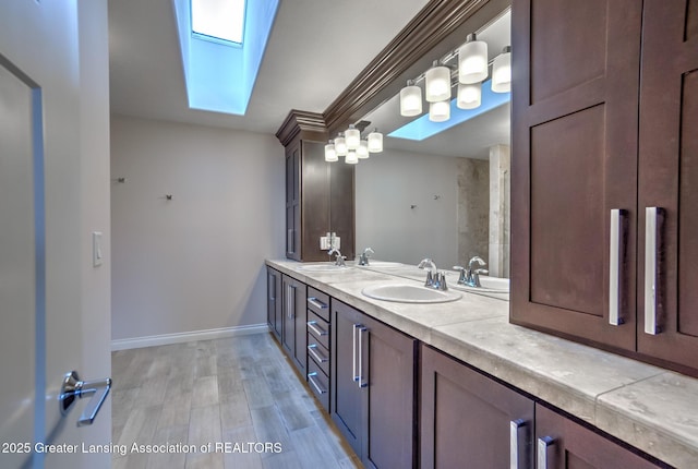 bathroom with wood-type flooring, vanity, and a skylight