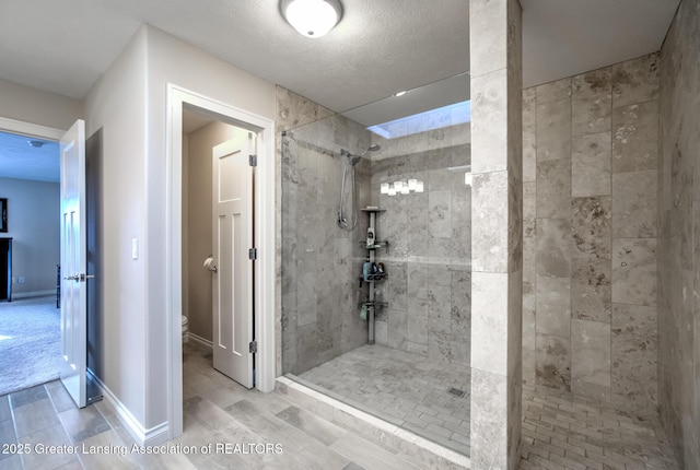 bathroom with toilet, a textured ceiling, and a tile shower