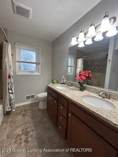 full bathroom with vanity, shower / bath combo with shower curtain, a textured ceiling, and toilet