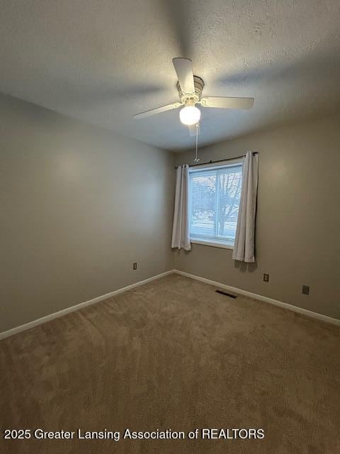 carpeted spare room with ceiling fan and a textured ceiling