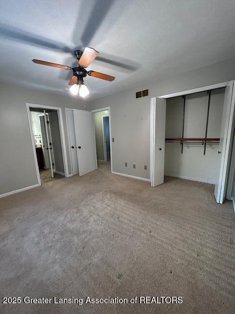 unfurnished bedroom with a textured ceiling, ceiling fan, and carpet