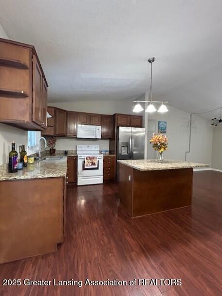 kitchen with dark hardwood / wood-style floors, pendant lighting, lofted ceiling, sink, and white appliances