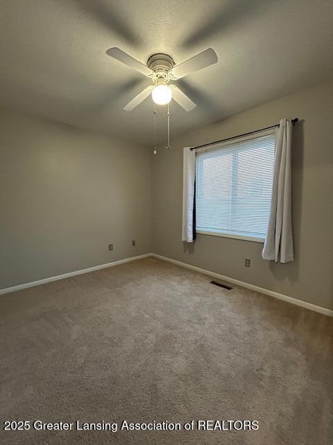 unfurnished room featuring ceiling fan and carpet