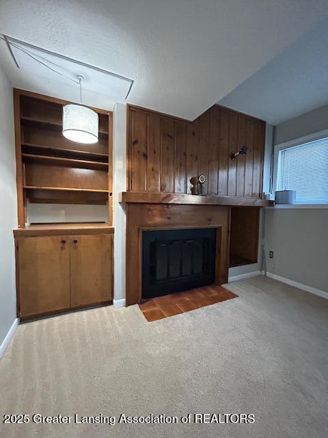 unfurnished living room with light colored carpet and built in features