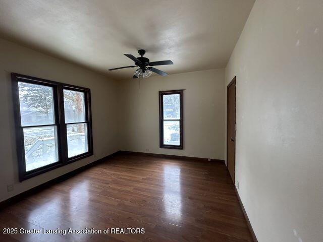 empty room featuring ceiling fan and dark hardwood / wood-style flooring