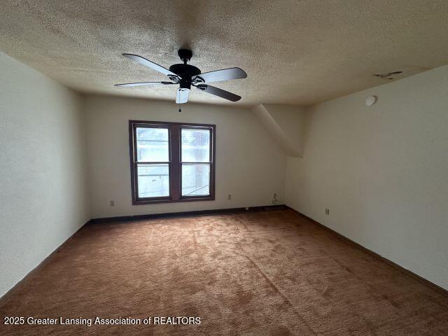 bonus room with ceiling fan, carpet, and a textured ceiling