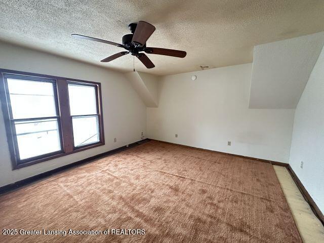 bonus room with ceiling fan, light carpet, and a textured ceiling