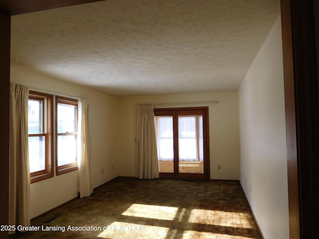 carpeted spare room featuring a textured ceiling