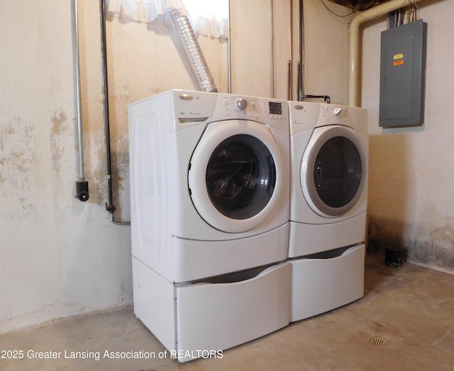 clothes washing area with washing machine and clothes dryer and electric panel