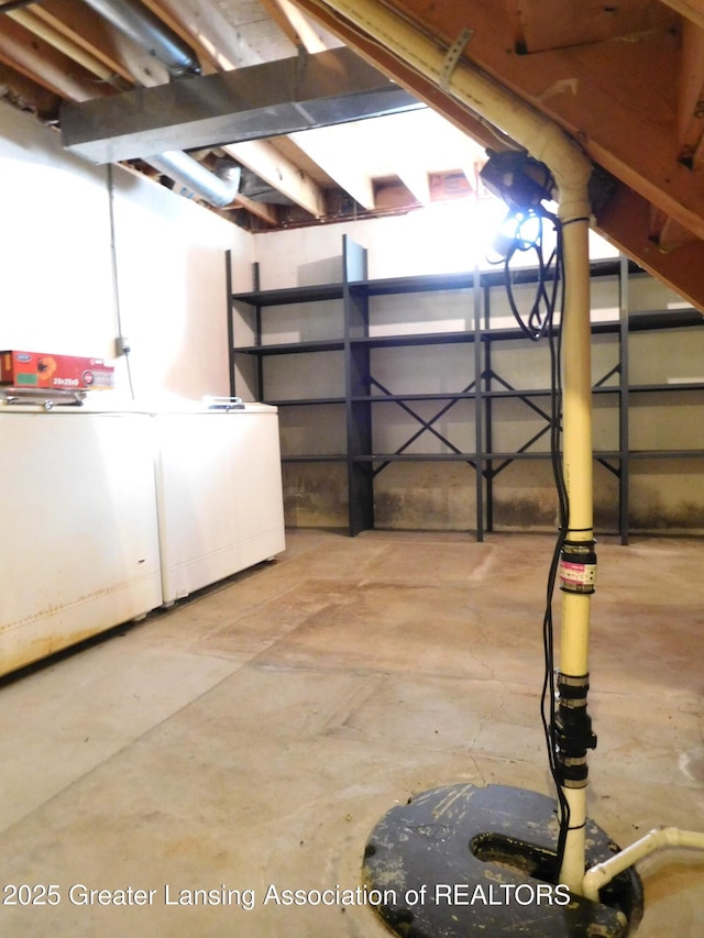 basement featuring fridge and washing machine and clothes dryer