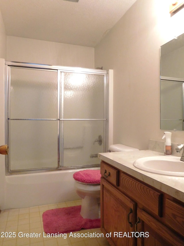 full bathroom featuring toilet, vanity, and bath / shower combo with glass door