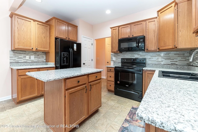 kitchen featuring backsplash, sink, a kitchen island, and black appliances