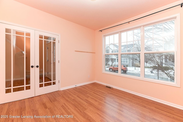 unfurnished room with french doors and light wood-type flooring