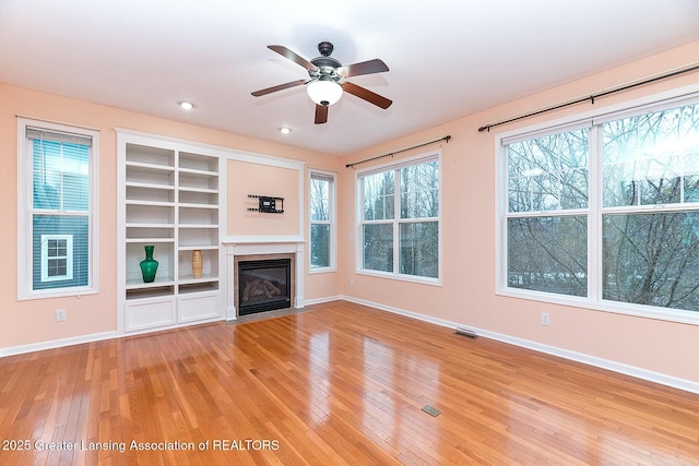 unfurnished living room featuring ceiling fan and light hardwood / wood-style flooring