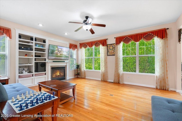 living room featuring wood-type flooring and ceiling fan