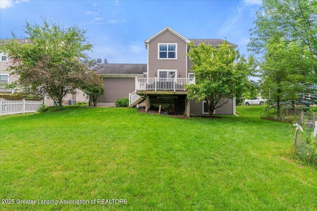 back of property with a wooden deck and a lawn