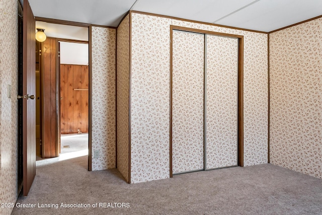 unfurnished bedroom featuring ornamental molding and carpet flooring