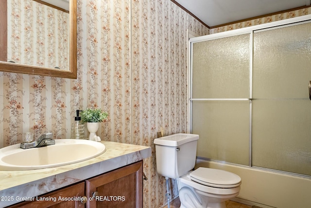 full bathroom featuring vanity, combined bath / shower with glass door, and toilet