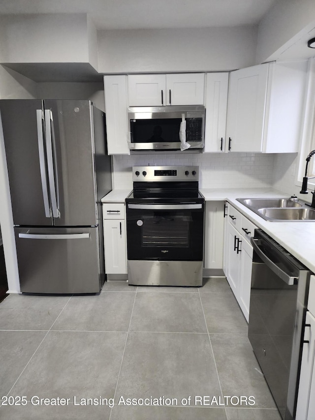 kitchen with stainless steel appliances, sink, white cabinets, and decorative backsplash