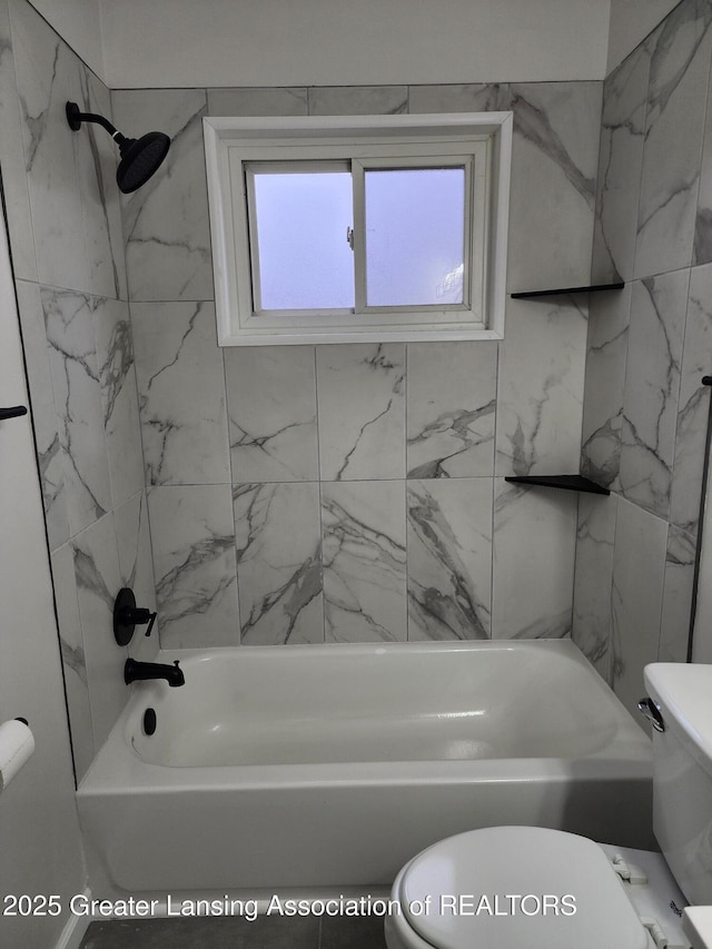 bathroom featuring tiled shower / bath and toilet