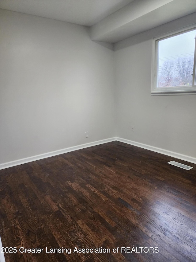 empty room with dark hardwood / wood-style flooring