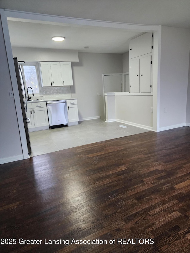 kitchen featuring white cabinetry, decorative backsplash, stainless steel appliances, and light wood-type flooring