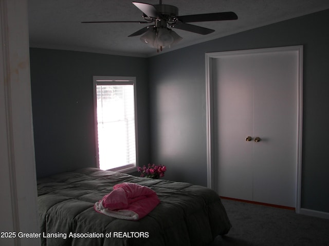 carpeted bedroom with ornamental molding and ceiling fan